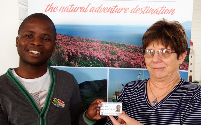 Links ontvang Ally Msweli van Gansbaai Toerisme sy identifikasiekaartjie as Toergids van Glenda Kitley, met die lapelwapen wat reeds op sy bors pryk